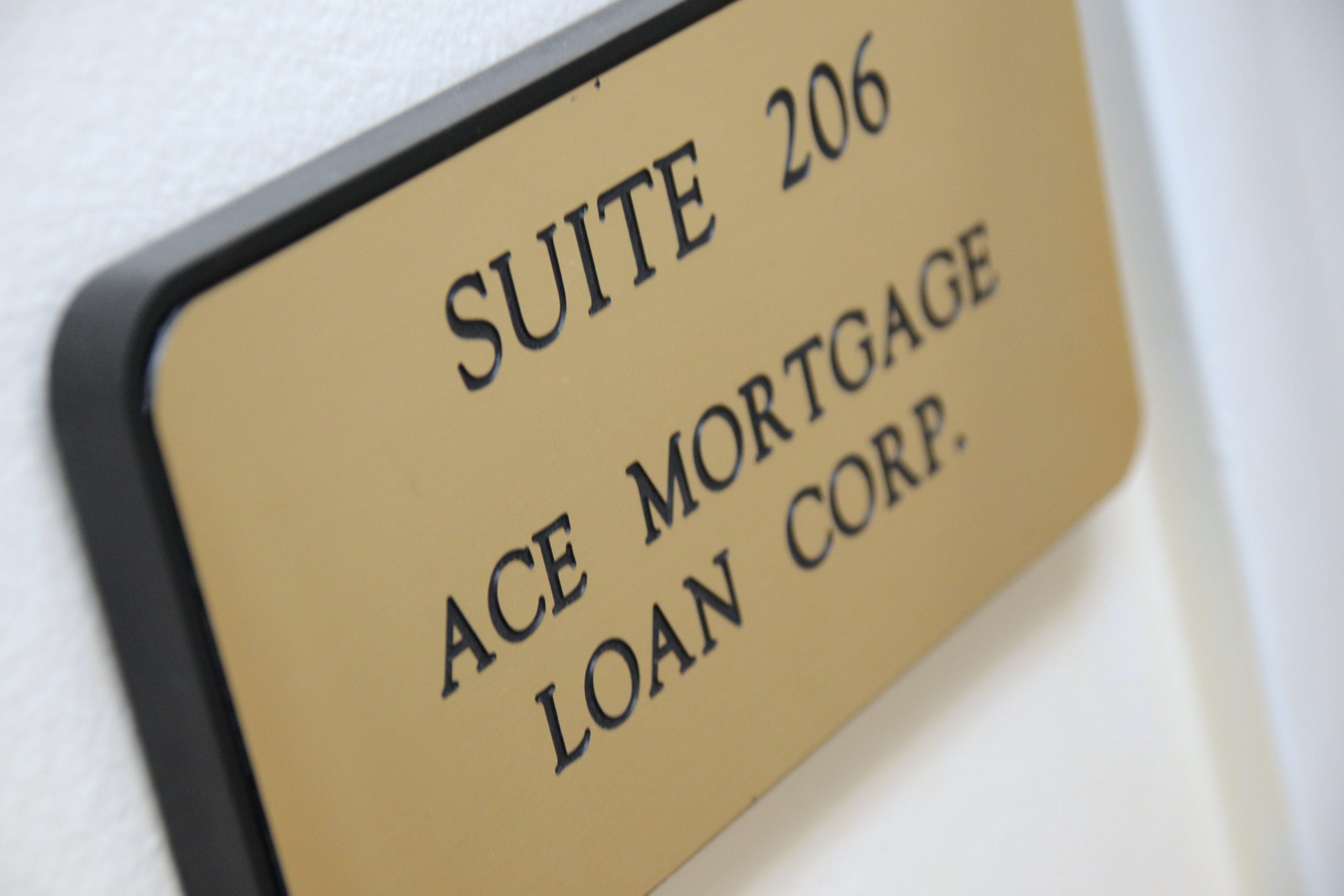Wall-mounted sign reading "Suite 206" for Ace Mortgage Loan Corporation, marking the office space.