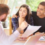 Mortgage lender explaining loan document to couple