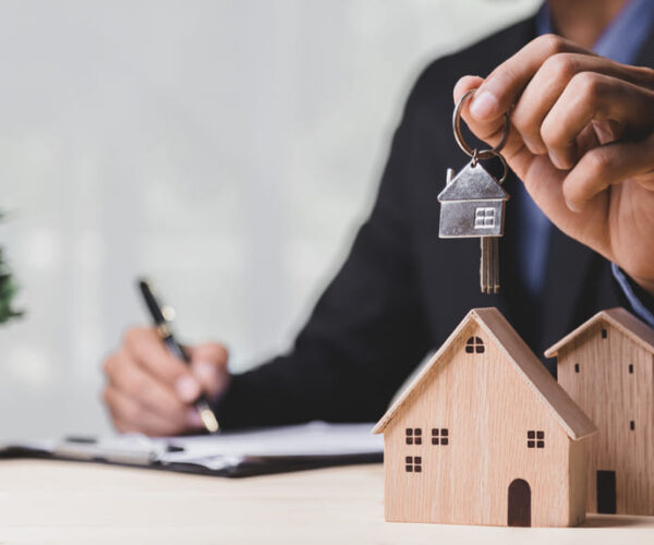 Business hand holding home - refinancing concept