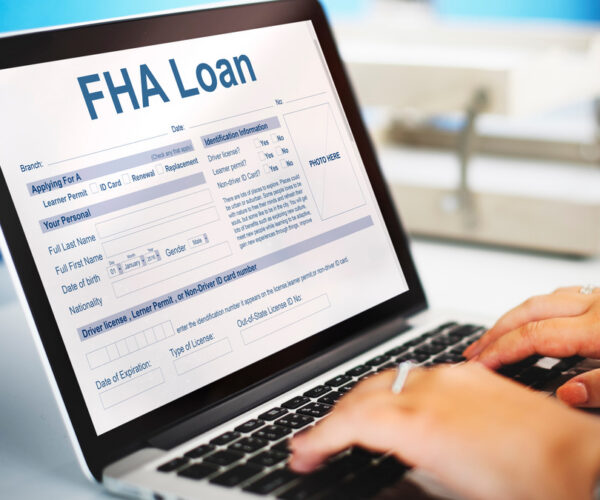 FHA Loan Federal Housing An agent filling FHA Loan Federal Housing Administration Lending form on laptop