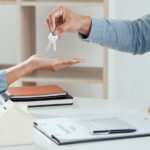 agent giving house keys to new buyer after signing agreement